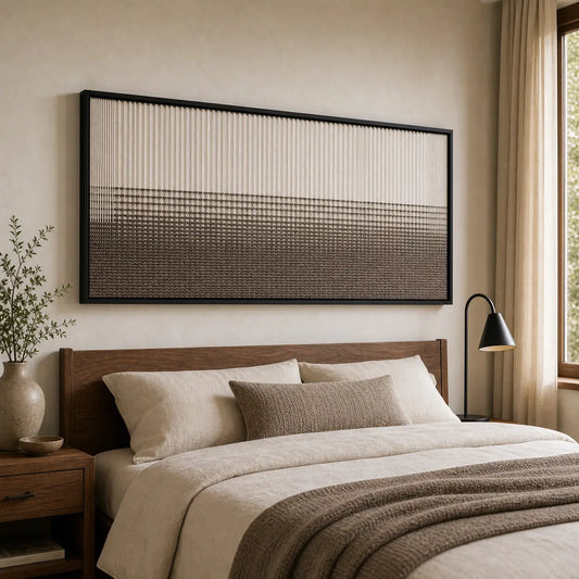 A beautiful hand-woven wool tapestry displayed beautifully above a styled bed with brown accents in a warm, cozy bedroom.