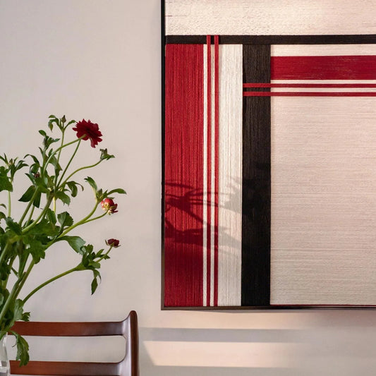 Angled view of Napoli RE002 textile art showing precisely arranged soft cotton cord, bold red and black panels, and clean geometric lines.