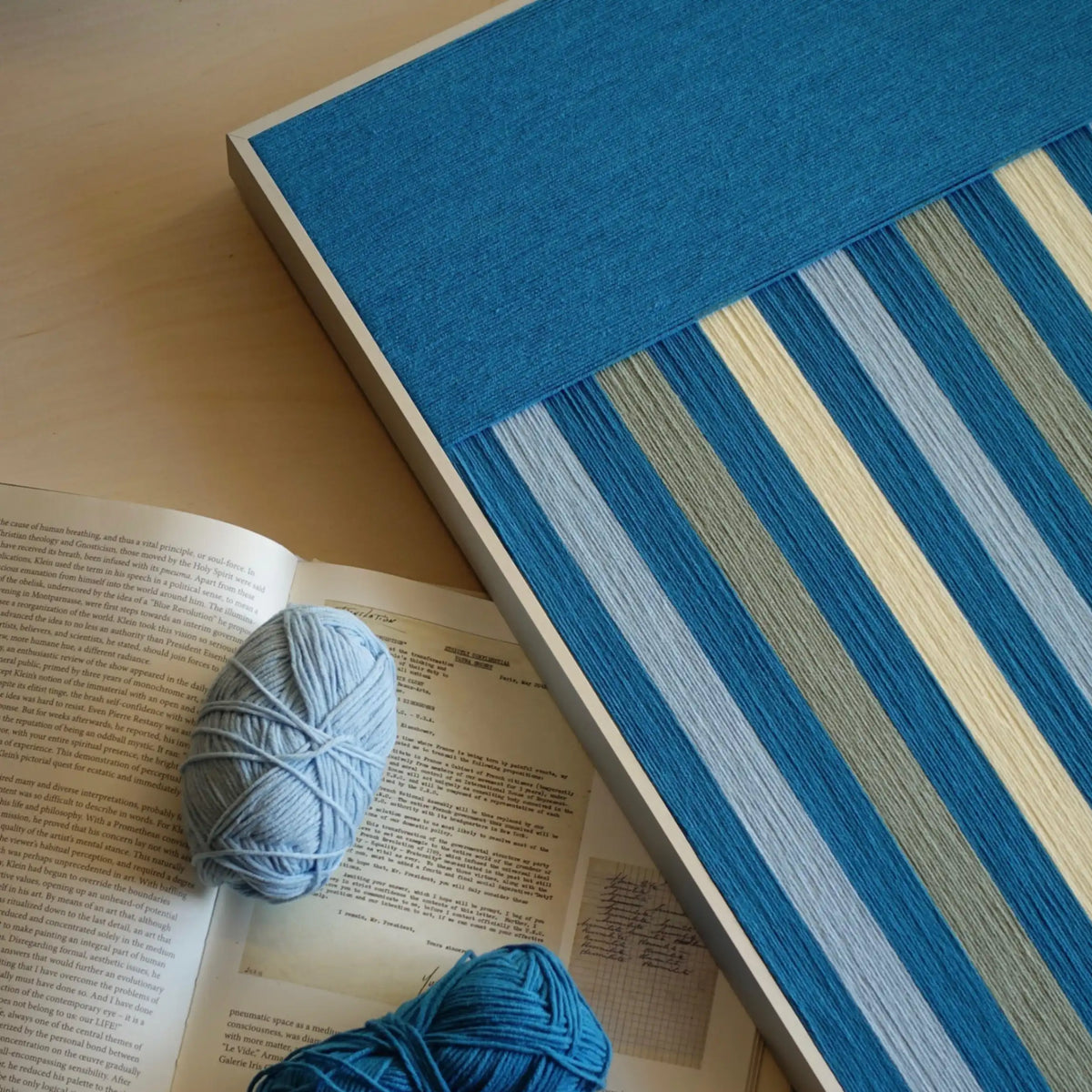 Angled close-up of Blue Night RE003 textile art highlighting its dense yarn wrapping and contrast between light and dark blue stripes.