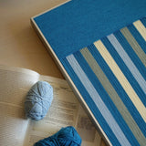 Angled close-up of Blue Night RE003 textile art highlighting its dense yarn wrapping and contrast between light and dark blue stripes.
