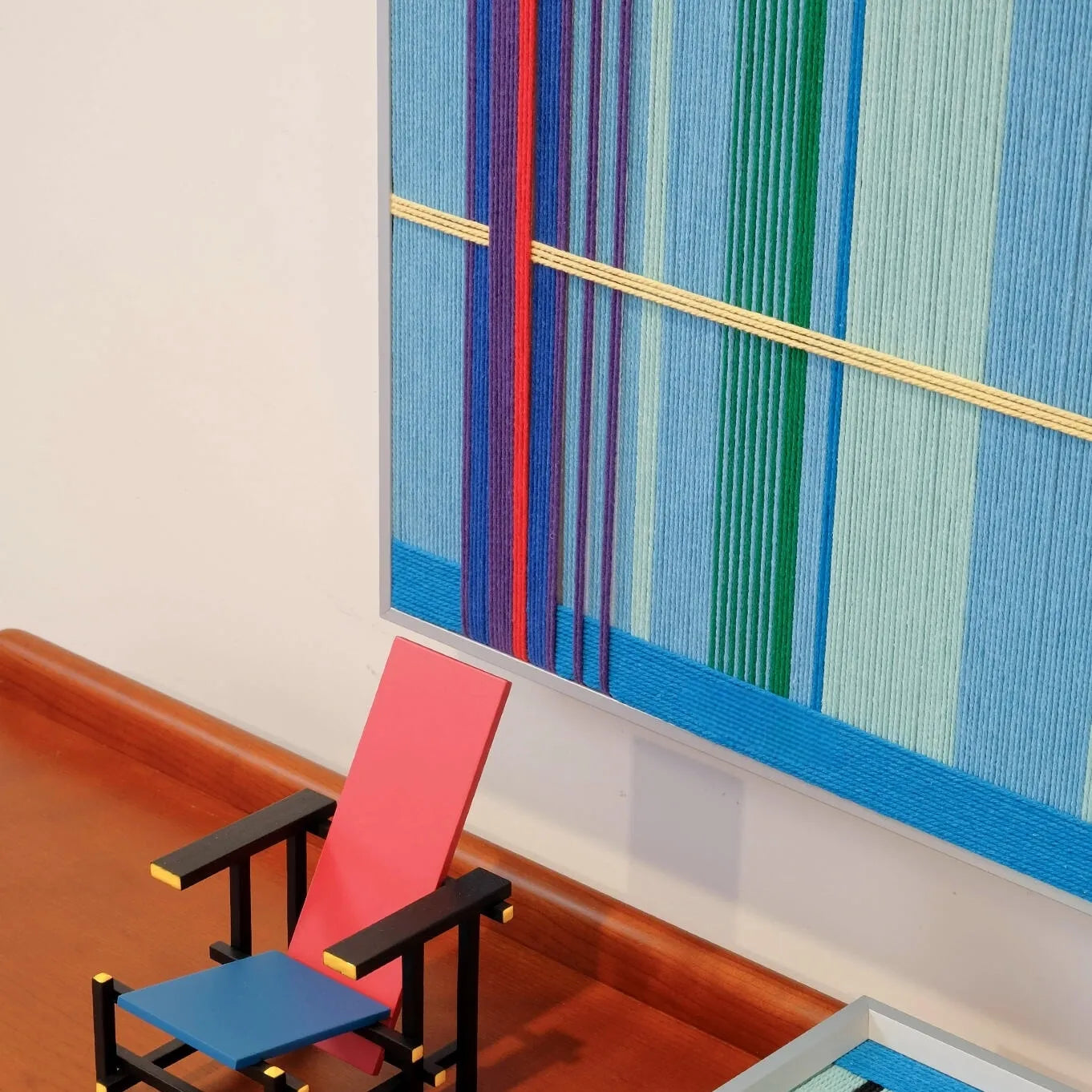 Summer Story RE004 yarn wall art displayed on a laptop, highlighting its compact framed format and cheerful yellow and violet grid design.