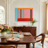 Rainbow Hearts RE005 framed fiber artwork featuring layered red, teal, lavender, and gray yarn blocks in a modern interior.
