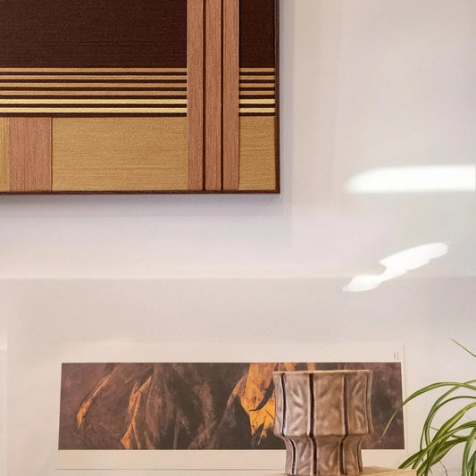 Rohmer RE014 framed fiber wall art in brown, tan, and cream displayed above a table with sculptural decor.
