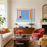 Summer Letter RE019 framed textile art with sky blue, lavender, yellow, orange, mint green, white, and red yarn displayed in a bright modern interior.