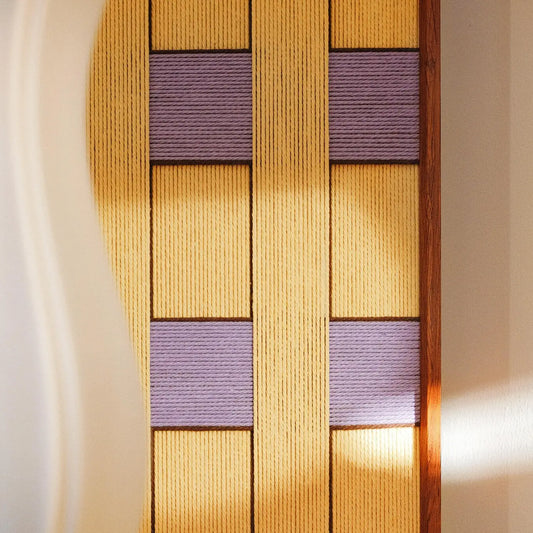 Close-up of Lavender Fields RE021 textile art showing intricate golden yellow and purple yarn winding and its framed edge.