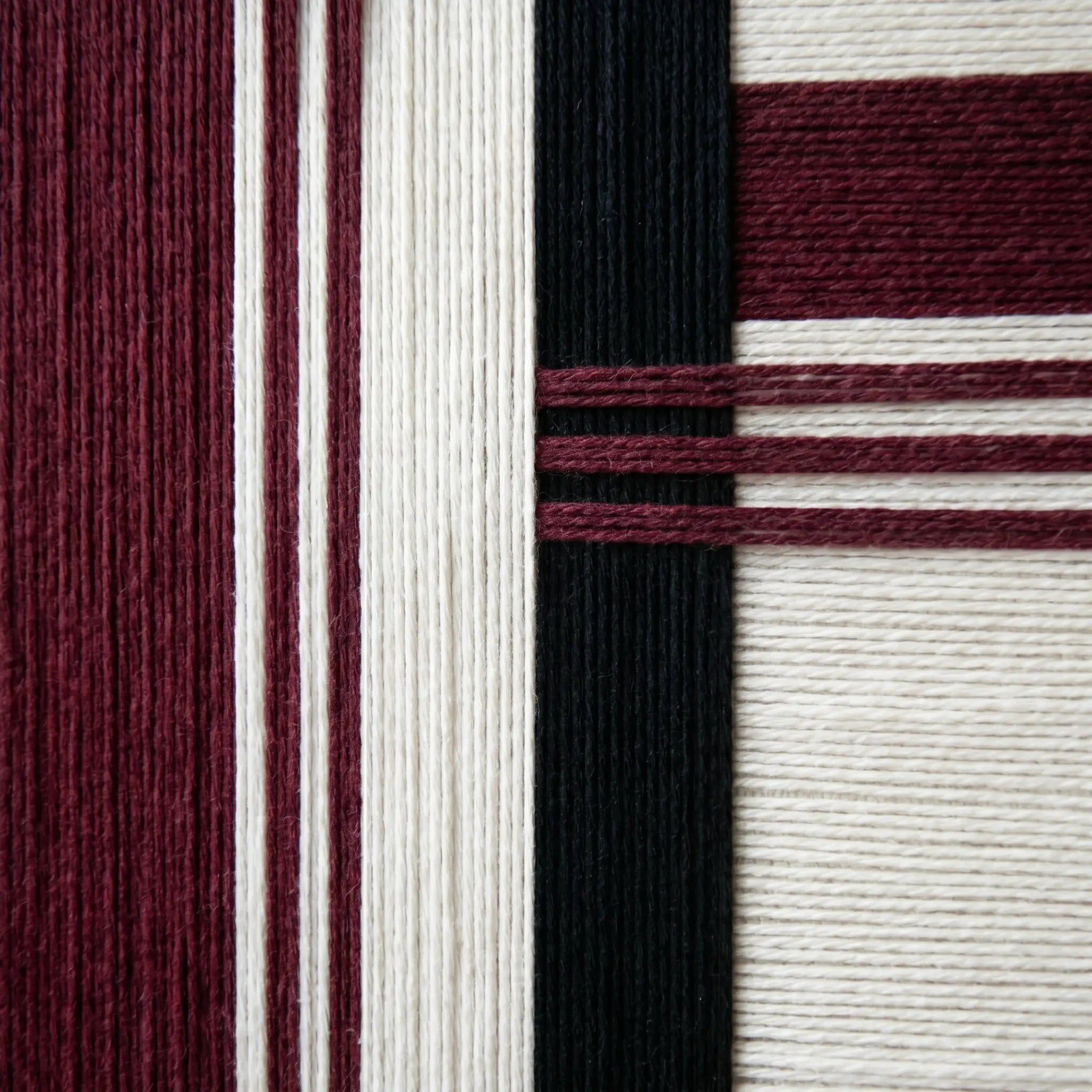 Macro close-up of Midnight Opera RE025 textile art highlighting rich burgundy and black soft cotton cord textures.