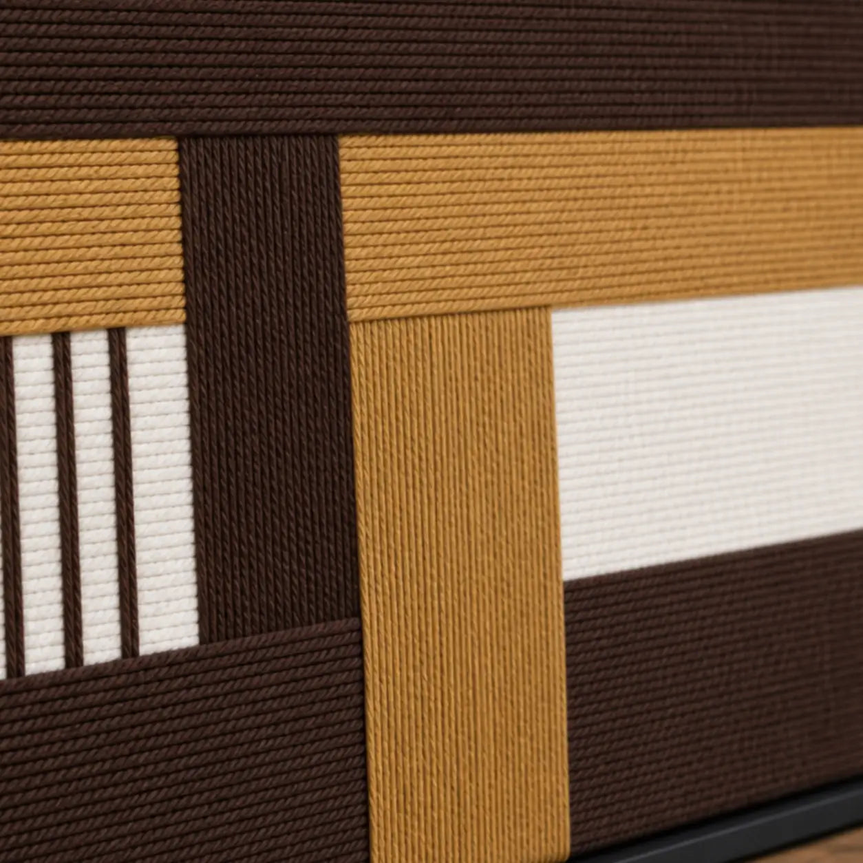 Macro close-up of Cocoa Loom RE029 textile art highlighting thick brown, beige, and white intersecting soft cotton cord textures.