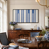 Blue Cadence RE031 framed fiber artwork featuring rhythmic denim blue and warm ivory vertical bands in a modern interior.