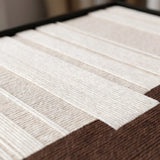 Angled macro detail of Ivory Rhythm textile art showing raised cream vertical yarn over a textured brown base.