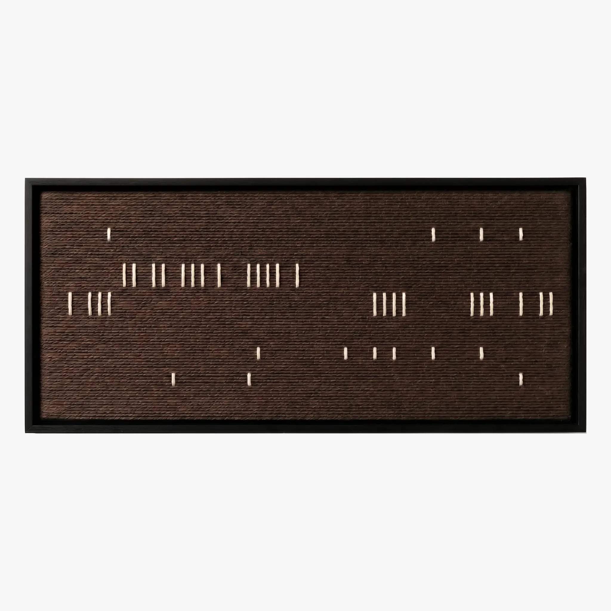 Front studio view of Cocoa Whispers textured wall art with scattered white vertical stitches on a dark brown background in a black frame.