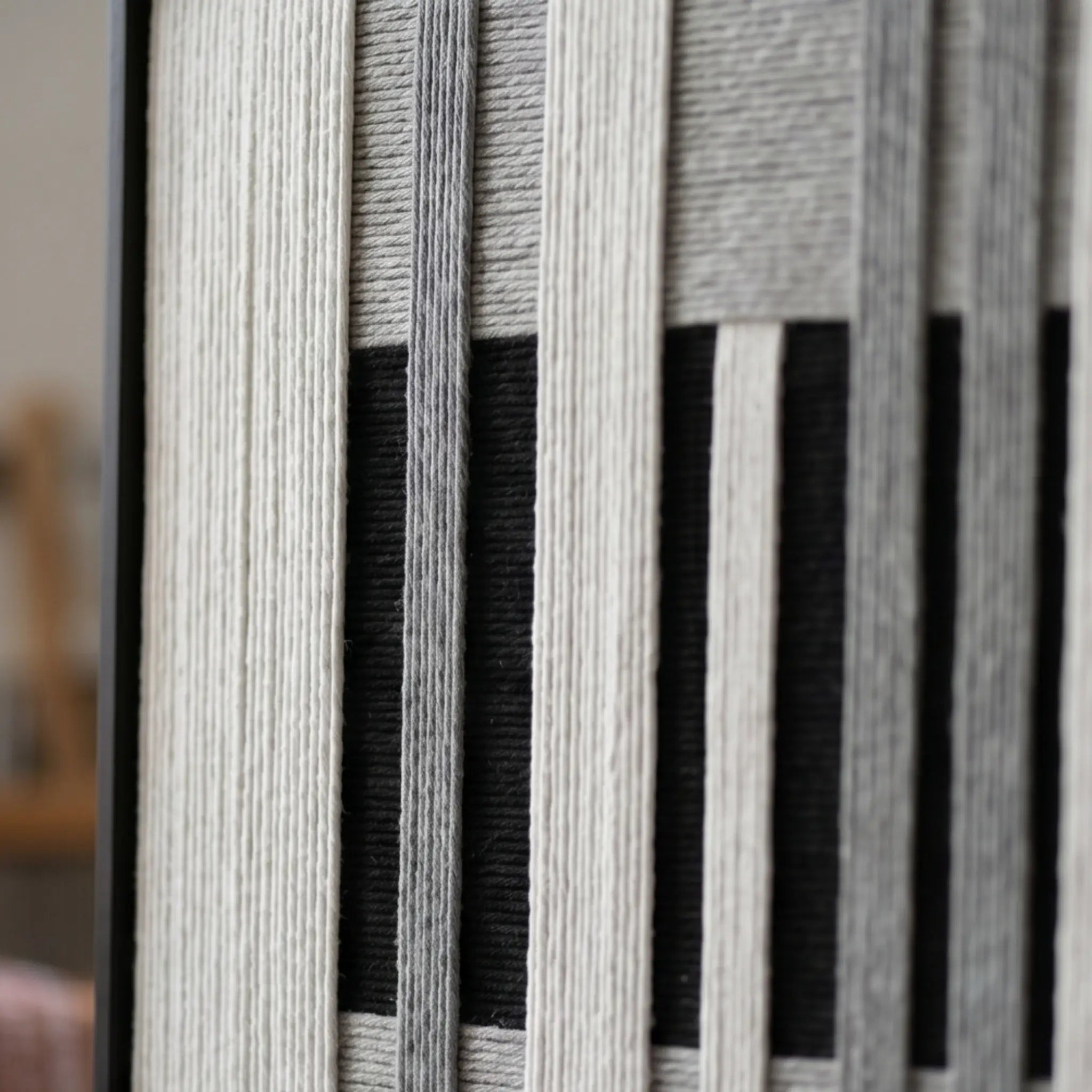 Macro detail of Monochrome Tempo textured textile art highlighting thick black, white, and grey yarn texture.
