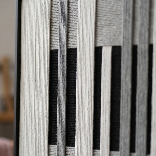 Macro detail of Monochrome Tempo hand-woven textile art highlighting thick black, white, and grey yarn texture.