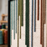 Macro detail of Chromatic Rain textured textile art showing raised green, blue, and terracotta yarn drops.