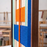 Side profile of Broadway Blocks framed textile art highlighting its multilayered yarn structure and sleek metal frame.