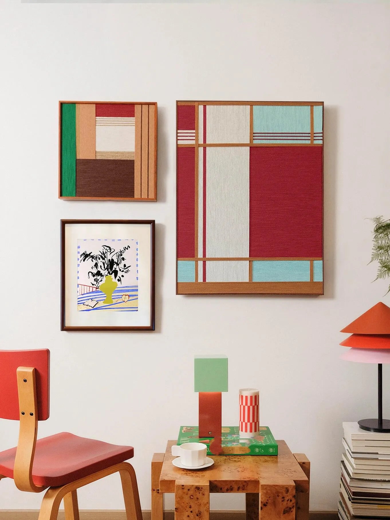 Red House wall art hung above a stool and desk in a cozy room setting, paired with complementary decor pieces, emphasizing its vibrant red and turquoise palette.
