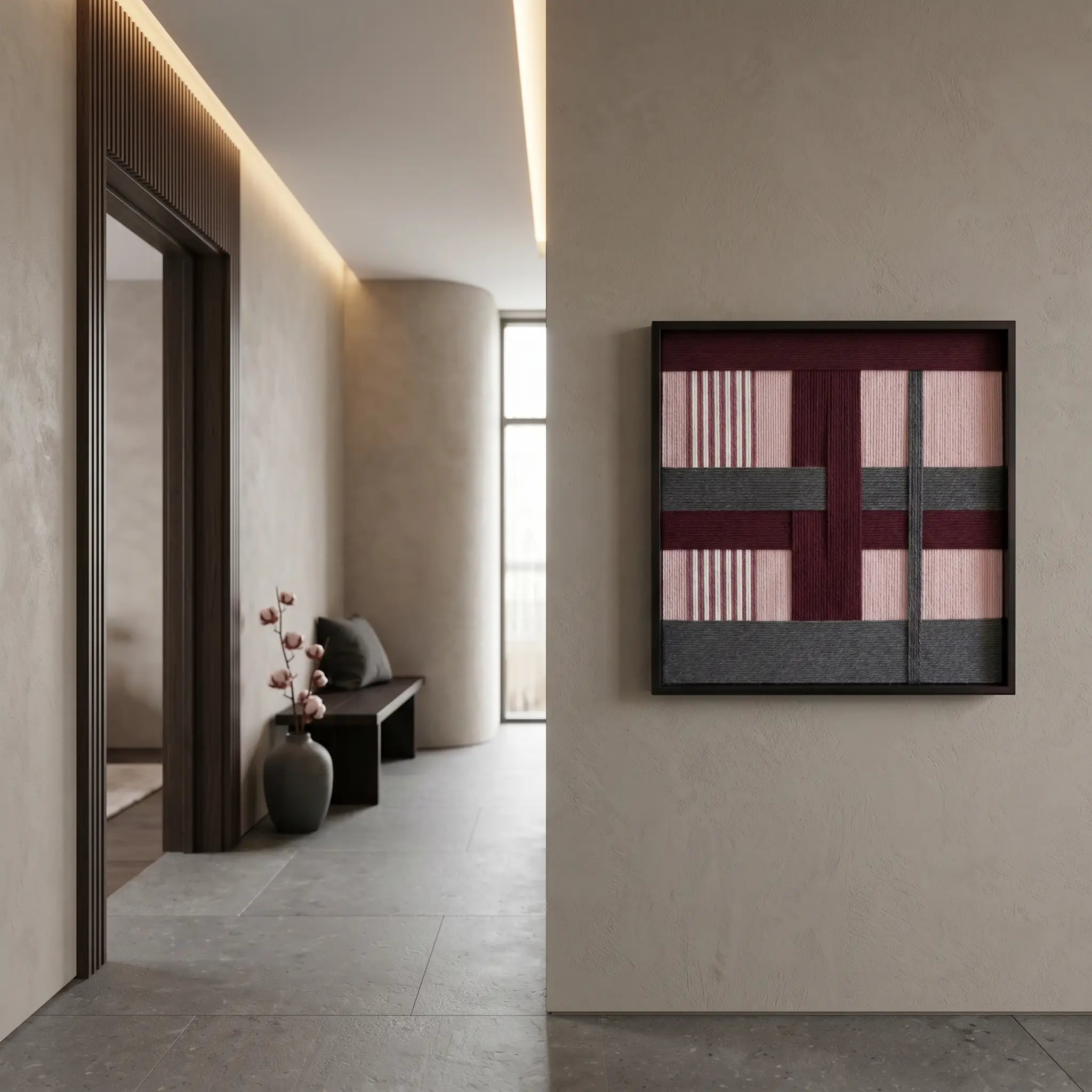 Framed textured fiber art hanging in a contemporary home foyer, showcasing its impact within a minimalist architectural space.