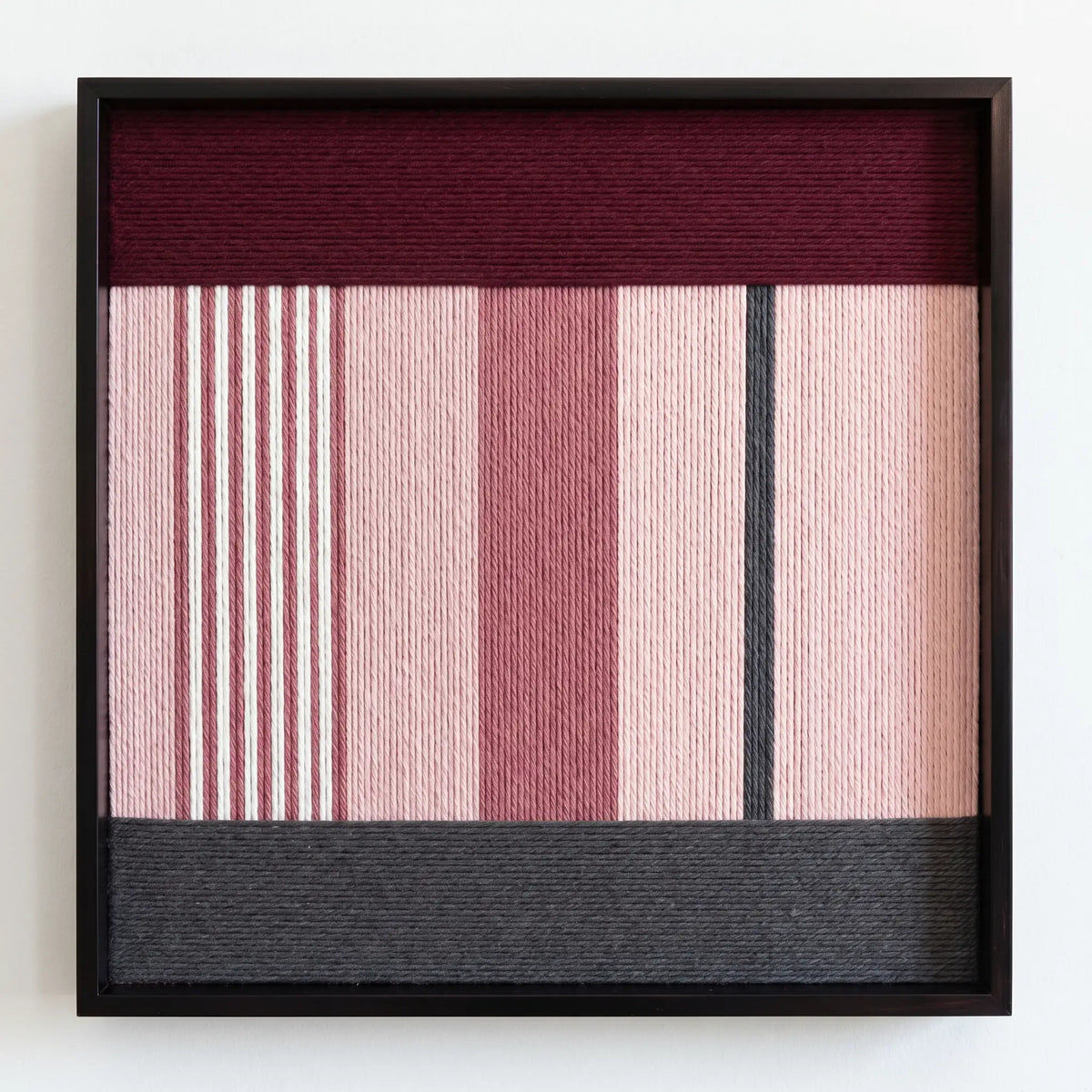 Direct front view of Rosy Pulse framed textile wall art showcasing dusty rose and white vertical stripes, a burgundy top band, and charcoal base.