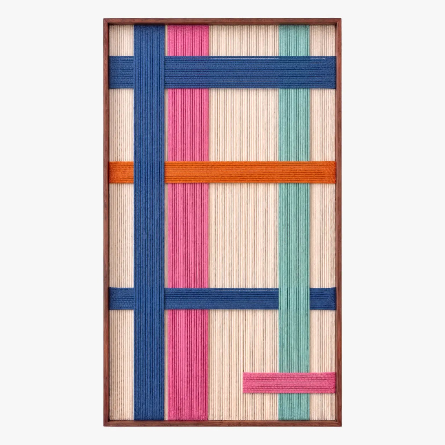 Full product shot of the vertical hand-woven wool wall art in a sleek metal frame, displaying geometric blocks of blue, orange, pink, and teal yarn.