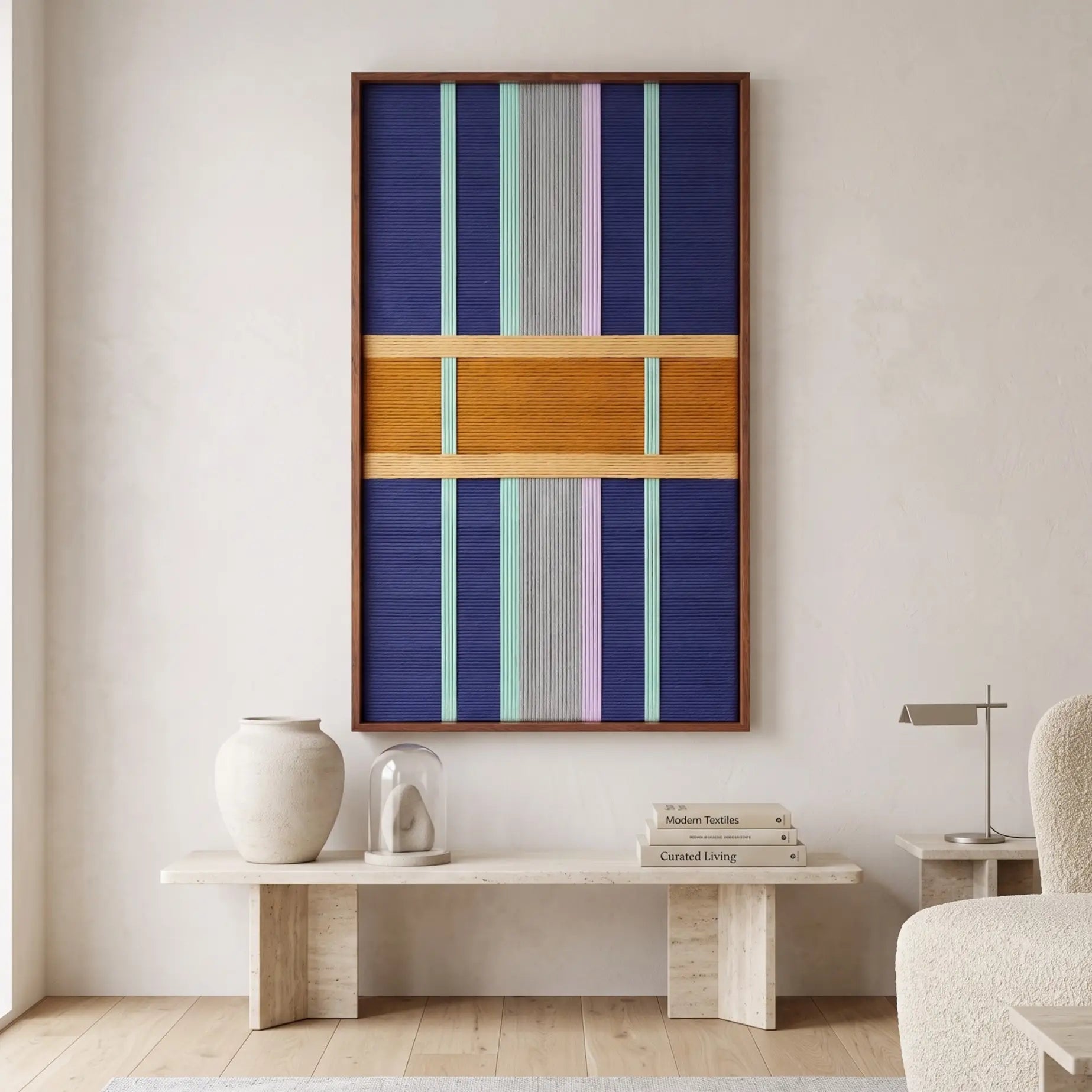 Modern interior setting showcasing the vertical hand-woven wool wall art hanging above a sleek stone console table with minimalist decor.