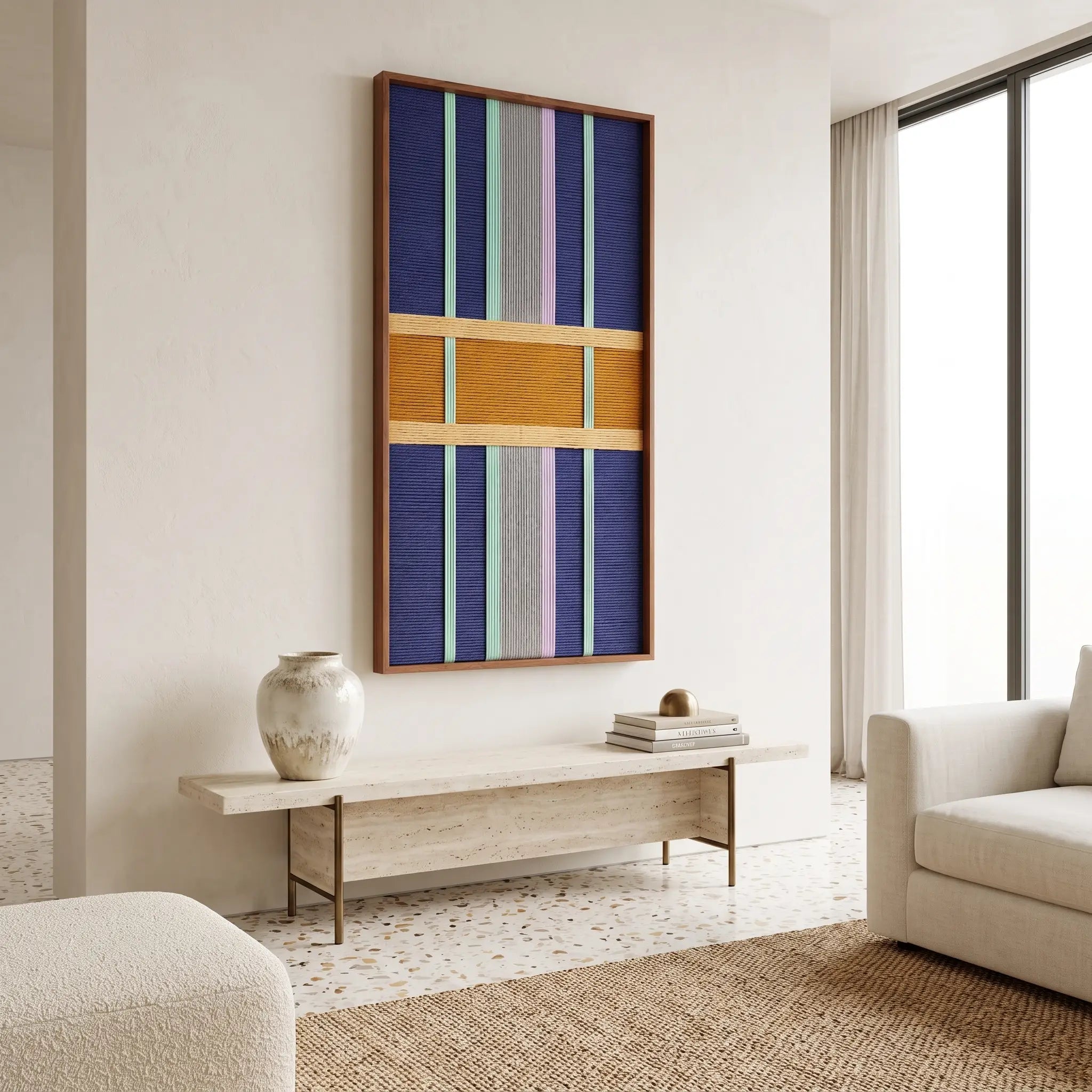 Contemporary lounge area styling featuring the framed textile art mounted on a neutral wall above a long wooden bench.