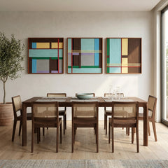 Framed three-piece geometric textile art set styled in a bright, modern dining room above a long wooden table and cane dining chairs.