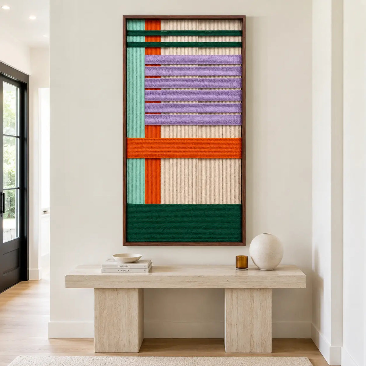 The Sedona Twilight hand-woven wool tapestry hangs elegantly above a minimalist stone console table in a bright modern home.