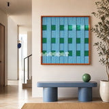 Seine Riverbank blue and green geometric yarn wall art displayed above a blue console in a bright modern entryway.