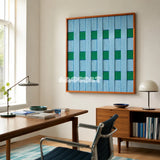 Seine Riverbank blue and green geometric yarn wall art displayed above a wooden desk in a sunlit home office.