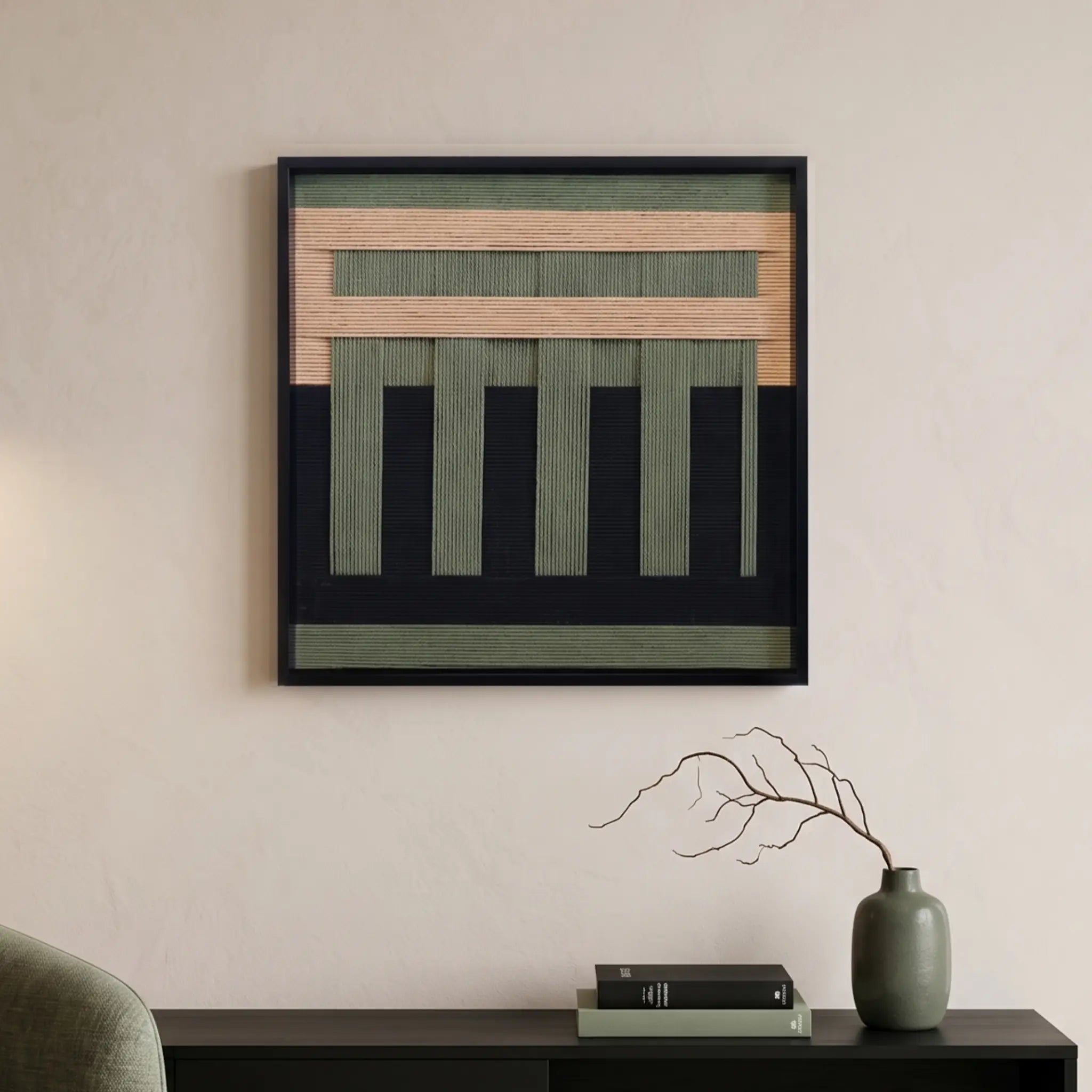 Hand-woven wool wall art with forest green and tan geometric patterns hanging above a black console table with minimalist decor.