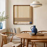 Shadow at 4 PM cream sand and slate blue textile wall art displayed above a round wood table in a warm modern dining room.