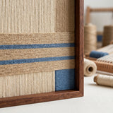 Macro close-up of the wooden frame corner and blue soft cotton cord stripes, highlighting the high-quality textured textile craftsmanship and dense texture.