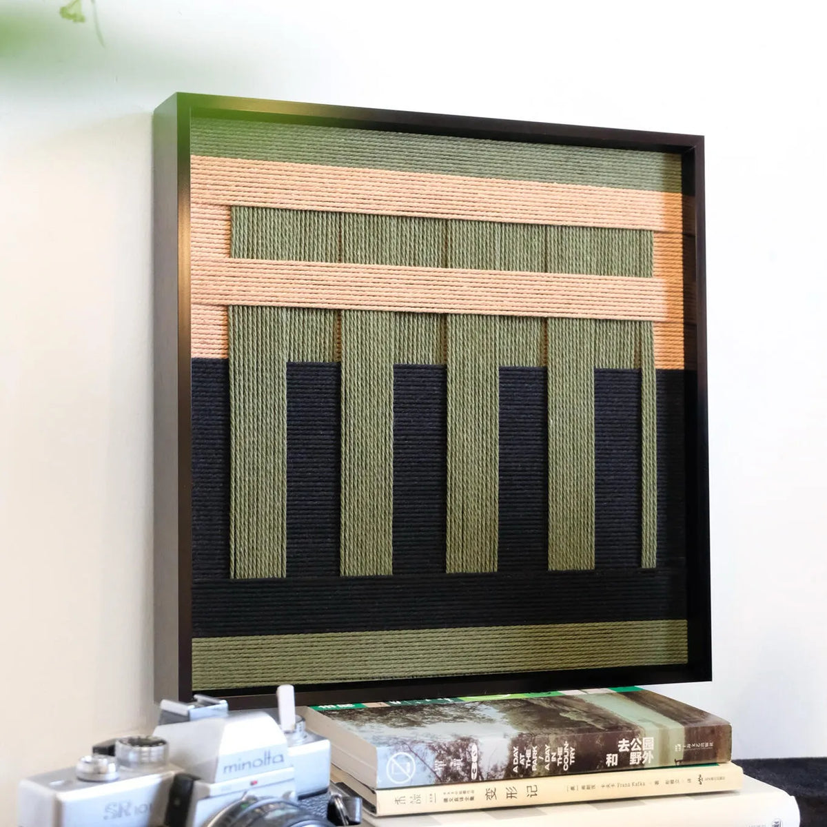 Side profile shot of the black-framed soft cotton cord art, demonstrating the deep shadow box frame and the tactile dimension of the weave.