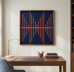 Framed fiber art tapestry with a rhythmic pulse design hanging in a professional home office setting featuring a wooden desk and lamp.