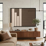 A large Silent Stelae framed wall art piece serves as the focal point above a mid-century wooden console in a bright living space.