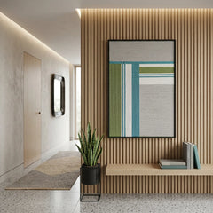 Vertical framed fiber wall art styled in a modern entryway with slatted wood wall panels and a minimalist bench.