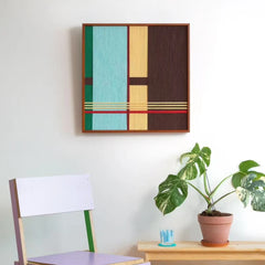 A single framed textured wall art piece hanging above a pastel chair, adding a touch of geometric modern design to the corner.