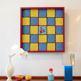 Snoopy's Space Odyssey red-framed blue and yellow checkerboard yarn wall art displayed above a decorative console.