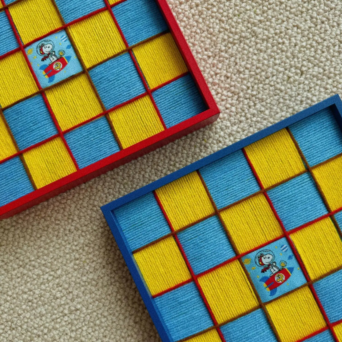 Two textured Snoopy art pieces arranged together, showing the thickness of the soft cotton cord fibers and the detailed craftsmanship of the blue fabric borders.