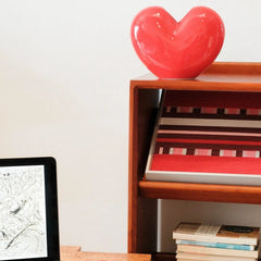 Spring Miss yarn wall art styled on a desktop with a decorative heart and stationery, emphasizing its playful color scheme and tactile weave.
