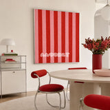 Hana and Alice SQ003 red and pink striped soft cotton cord wall art beside red chairs in a bright modern dining room