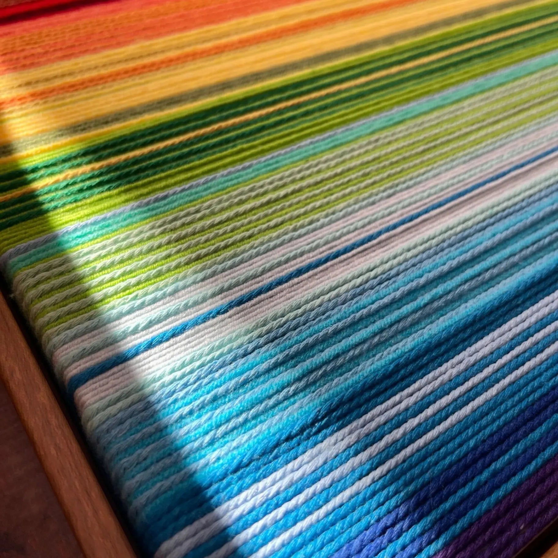 Close-up of Rainbow SQ004 soft cotton cord transitioning through green turquoise pale blue cobalt and violet bands