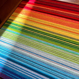 Close-up of Rainbow SQ004 soft cotton cord transitioning through crimson red orange yellow green and blue bands