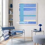 Blue Sea SQ008 blue cyan silver and yellow soft cotton cord wall art beside a blue lounge chair in a modern reading corner