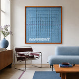 Blue Bridge Over the Pond SQ024 light blue framed yarn art above a blue sofa in a bright modern living room