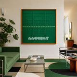 Green Shadow Weave SQ025 emerald green framed yarn art above a green sofa in a bright modern living room