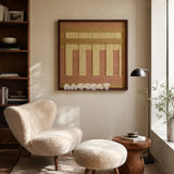 Autumn Mountain SQ034 tan blush and golden yellow framed yarn art beside a cream boucle chair in a sunlit reading corner