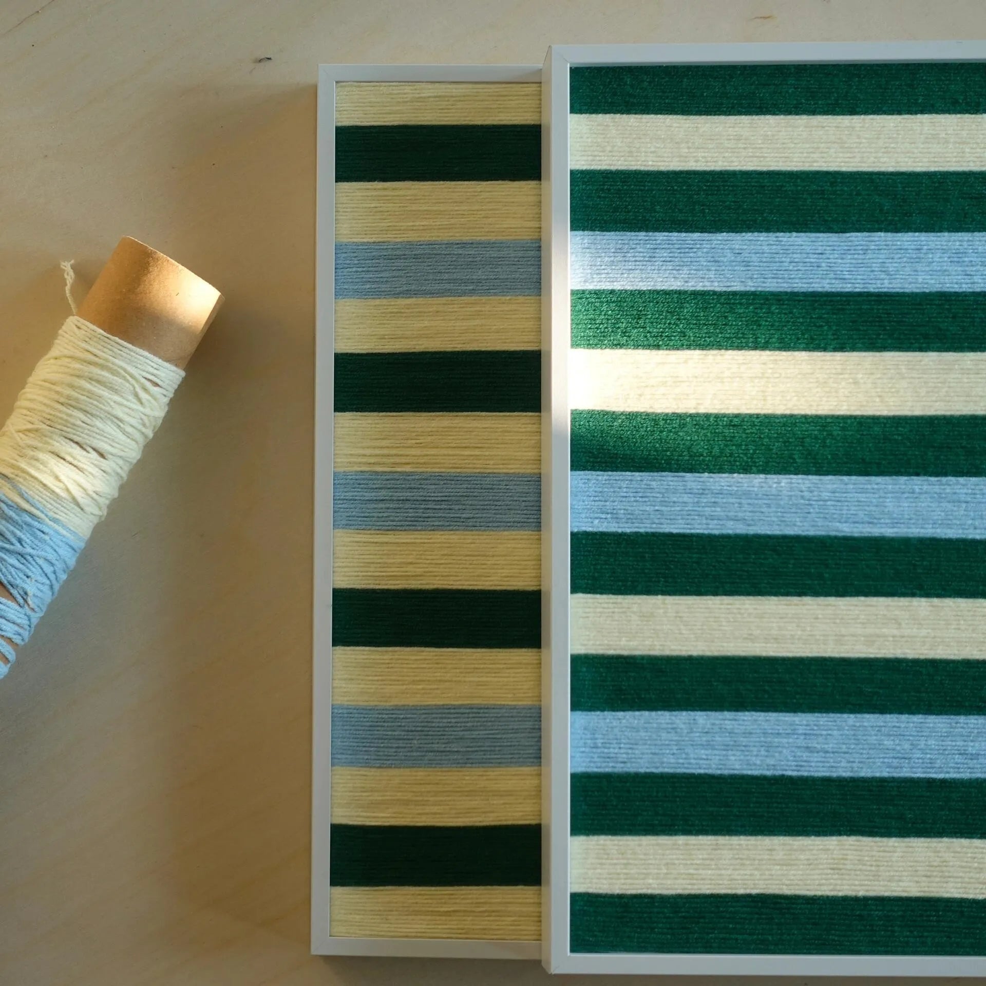 Horizontal and vertical Spring Lake SQ039 striped yarn artworks overlapping beside cream and blue yarn materials