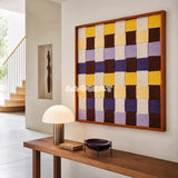 Mrs Dalloway SQ043 purple yellow cream and brown framed yarn art above a wood console table in a bright modern entryway