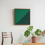 Azure Sky Woven Green Forest fiber wall art displayed above a dining table with a potted plant