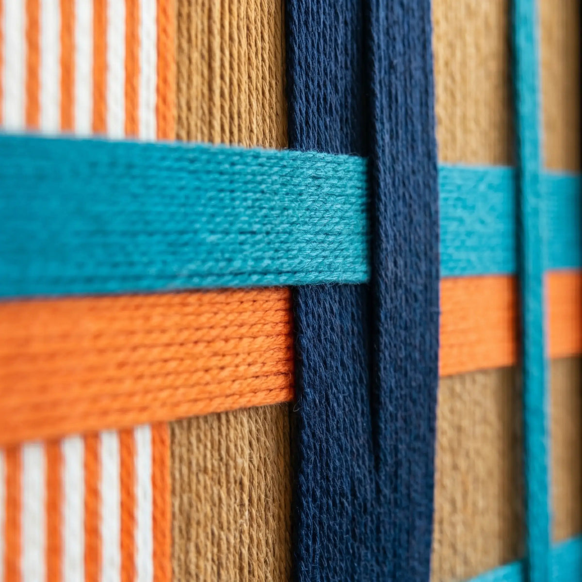 Macro view of Tropical Glow SQ089 showing interlocking navy and orange soft cotton cord texture.